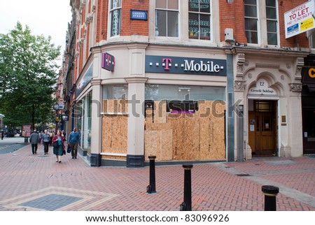 BIRMINGHAM - AUGUST 11 : A T-mobile store boarded up after rioters looted it on August 11, 2011 in Birmingham, UK.