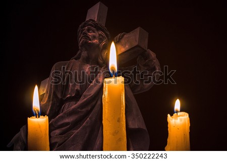 three burning candles on the background of Jesus with the cross on his shoulder