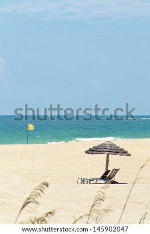 Beach with a sun umbrella and a yellow flag in Miami, Florida