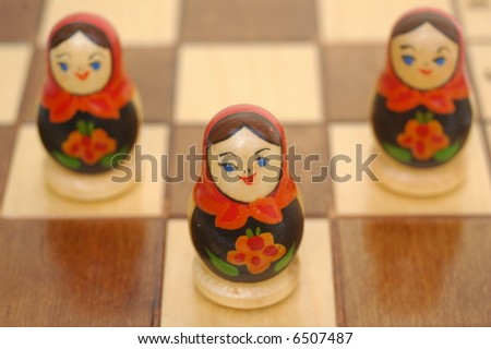 Painted wooden dolls on chess board