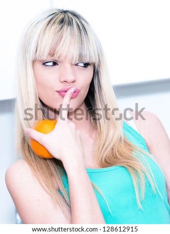 woman hesitating between a candy bar and an orange