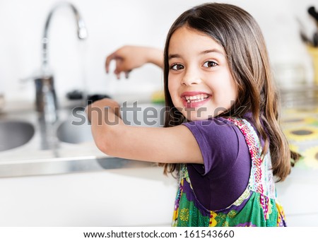 Expressive portrait of very cute girl washing hands