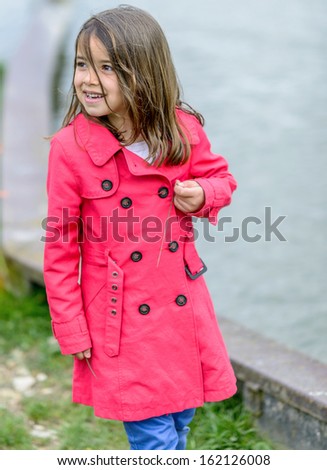 Natural portrait of cute child with greenery and water in the background