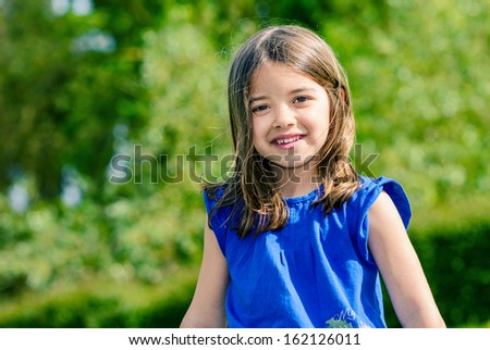 Natural portrait of cute child with greenery in the background