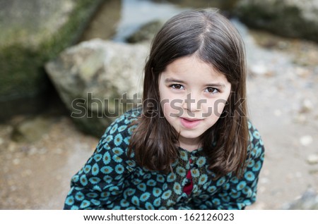 Natural portrait of cute child with rocks in the background