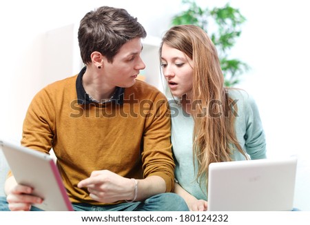 Beautiful young man showing something in his girlfriend on a touchpad