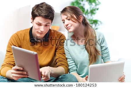 Beautiful young man showing something in his girlfriend on a touchpad
