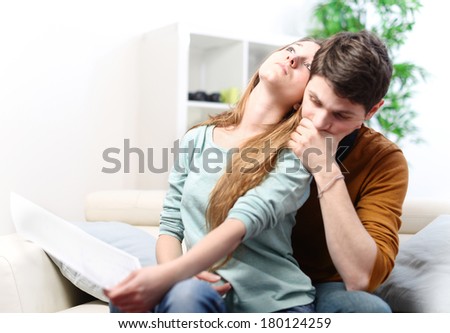 Young anxious couple consulting their bank account