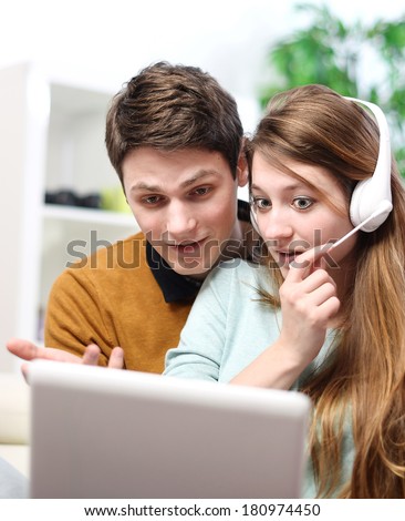 Happy young couple talking through the computer with video chat