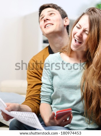 happy young couple consulting their bank account with joy