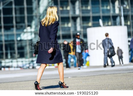 Back view of Young business woman leader walking on the city street