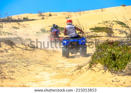 Two quads racing after one another and raising a lot of dust in the deserted areas