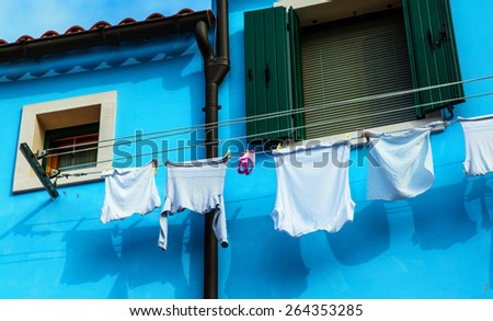 Colorful house in Burano with the laundry drying on a wire