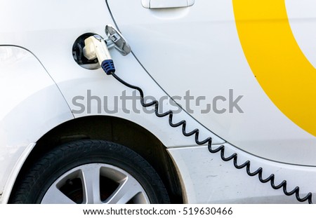 Electric Car Being Charged. Charging an electric car with the power supply plugged in.