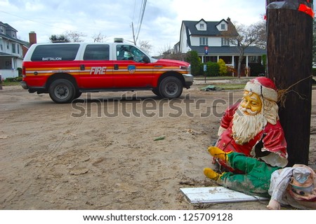 BELLE HARBOR, NY - NOV 1, 2012: Following Hurricane Sandy, an FDNY truck drives on a sand covered street in Belle Harbor, NY past Christmas ornaments from a flooded basement on November 1, 2012.