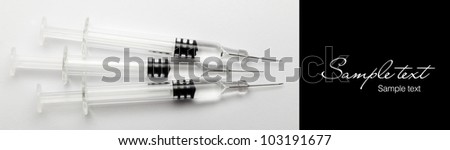 Syringes with the vaccine on a light gray background, close up (with sample text)