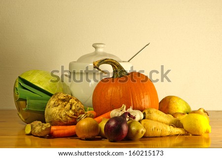 The beauty of fall as a still life with soup vegetables and a soup tureen on a wooden table