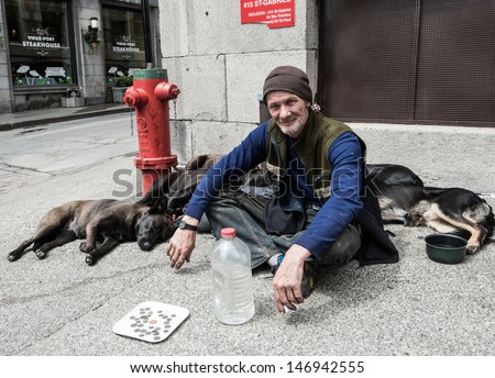 MONTREAL, QUEBEC, CANADA, MAY 24 - Homeless man with his five dogs on a street side in Montreal, Quebec, on May 24, 2013. Homelessness in the city of Montreal had grown to 30,000 people last year.