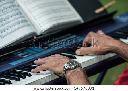 Old man playing a piano keyboard