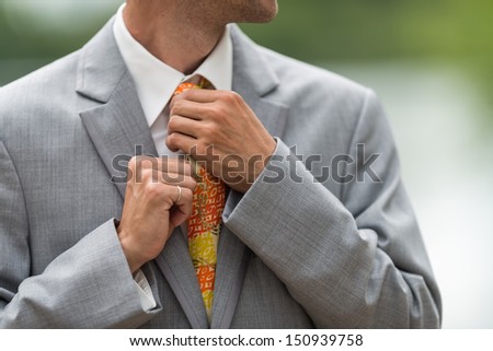 Man fixing his tie during wedding