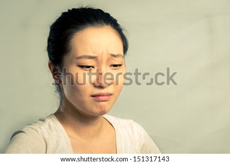 Young woman crying and wiping tears, with fashion tone