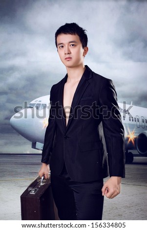 Young man with suit case ready for business trip at airport