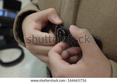Close up of a pair of hands tightening a belt buckle