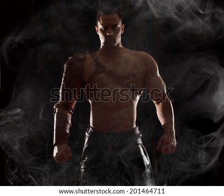 Portrait of a handsome muscular ancient warrior.Muscle man on dramatic light