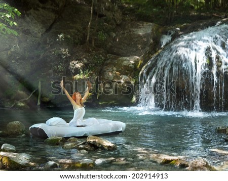 A hidden place. Sleeping woman in deep forest lies on matrace. waterfall on back
