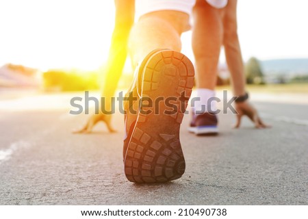 Athlete runner feet running on treadmill closeup on shoe.Mans fitness with the sun effect in the background and open space around him