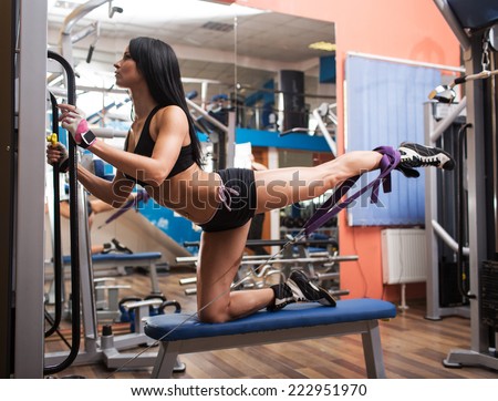Sporty girl in the gym demonstrates the exercise of hip crossover