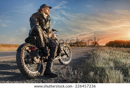 Biker man looking on sunrise