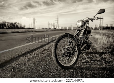 Motorbike.Road and city with open sky on background.Vintage effect added