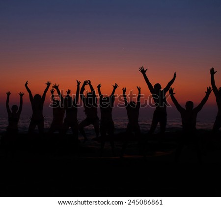 People silhouettes with raised hands with goa sunrise gradient on background
