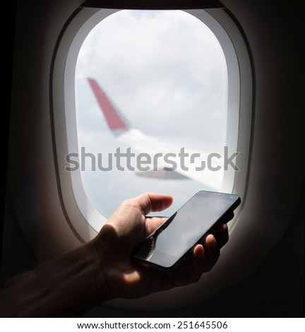 hand holding mobile phone with flight mode in the airplane