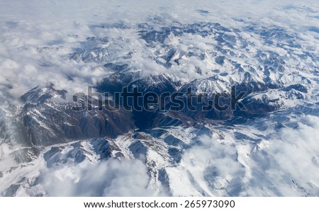 Tibet mountains. view from the airplane window at the snow-covered mountain peaks clouds
