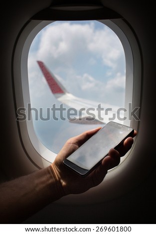 hand holding mobile phone with flight mode in the airplane