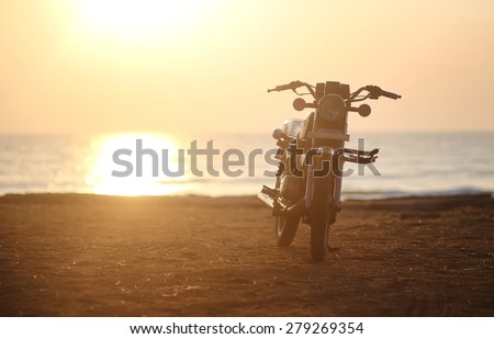 Motorcycle.Photo Motorcycle at sunset on a sandy beach in Goa, India.