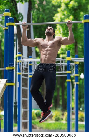 athlete doing pull-up on horizontal bar.Mans fitness outdoor