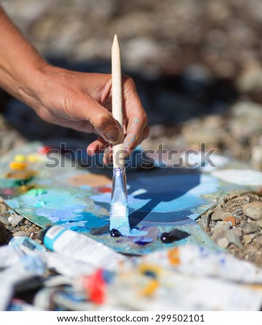 Artist hands with palette on ground