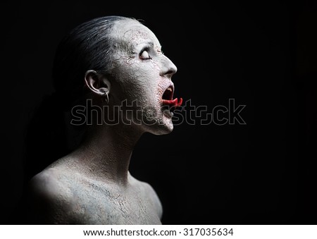 female demon.Art studio shot.Goth girl with sliced tongue