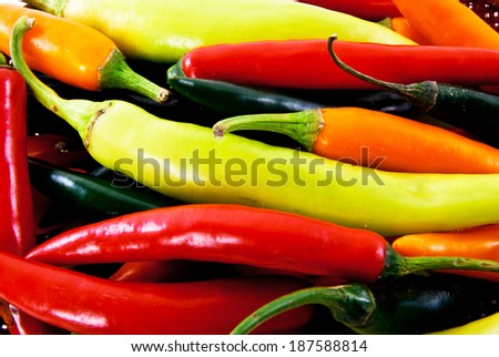 Mixed Kind of Hot Chili Peppers Red,Orange and Green with Woven Basket isolated on white background.