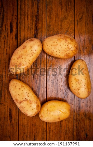 Group of Fresh Potato Arrange in Circle Round Shape on Wood Table , Country Rustic Style for background and texture.