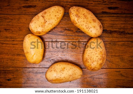 Group of Fresh Potato Arrange in Circle Round Shape on Wood Table , Country Rustic Style for background and texture.