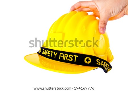 Engineer or Worker Hand Picking Yellow Safety Helmet Hat with SAFETY FIRST word tag Ready to wear, Putting Hat on Head / isolated on white background.
