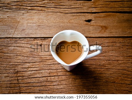 Coffee Mug in Design of Heart Shape, Love and Romantic or Valentine's Concept and idea on Wood Table Background, Rustic Style.