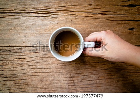 Hand Holding to Drinking Coffee White Mug (Simple Minimal) on Wood Table Background, Rustic Style.