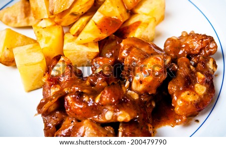 Barbecued Pork Spare Ribs Chopped and French Fries Potato Wedges on Wood Table Background, Rustic Still Life Style / Homemade Menu.