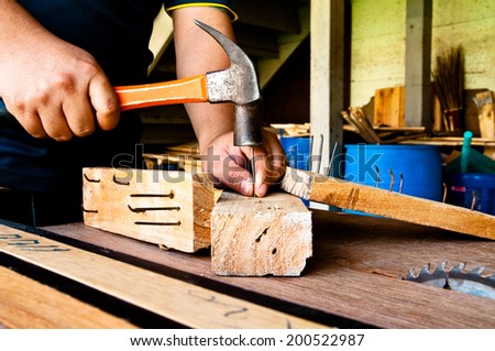 The Carpenter Hammering Down a Nail to Wood, Making a Furniture / Concept and Idea of Carpentry Business and Carpenter Wood Work.
