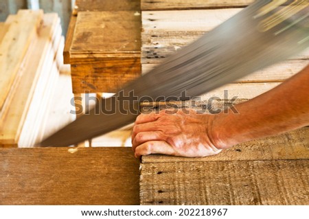 Moving Shot of The Carpenter Sawing Down Wood, Cutting, Making Furniture by Hand / Concept and Idea of Workshop Carpentry Business and Carpenter Wood Work. Real Still Life Style.